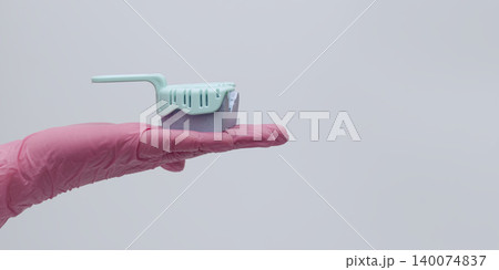 Dentist hand in a pink glove holding a dental impression tray. Large copy space for banner or text. 140074837