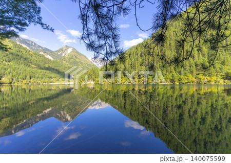 Amazing view of Mirror Lake with crystal clear water among mountains and evergreen woods in Jiuzhaigou nature reserve (Jiuzhai Valley National Park),China.  140075599