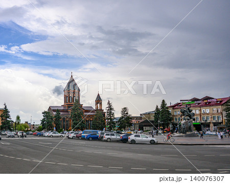 Urban scene featuring church, cars, and people in city square Urban scene featuring church, cars, and people in city square 140076307