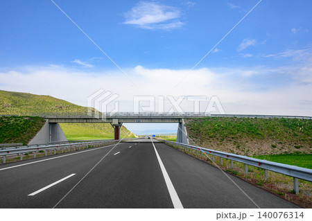 Open road leads under concrete bridge Open road leads under concrete bridge 140076314