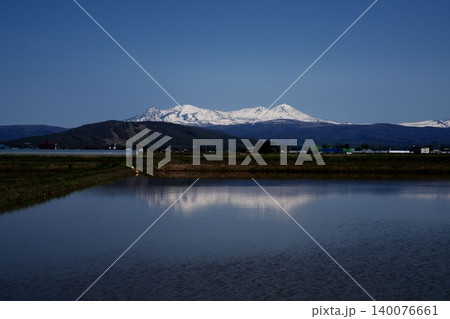 北海道鷹栖町の田植え前の水鏡水田に映る残雪の旭岳、青空、春の田園 北海道鷹栖町の田植え前の水鏡水田に映る残雪の旭岳、青空、春の田園 140076661