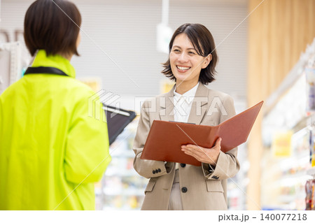 スーパーマーケット　店舗のスタッフと相談する社員の女性 140077218