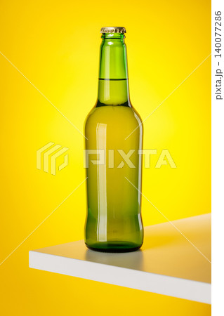 Green glass beer bottle on yellow background minimal studio composition 140077286