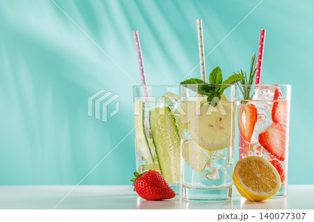 Set of fresh non alcoholic drinks with strawberry cucumber and lemon on blue background Set of fresh non alcoholic drinks with strawberry cucumber and lemon on blue background 140077307