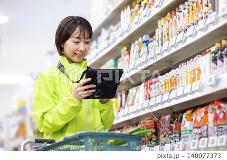 オンラインネットスーパー　商品をピックアップする女性スタッフ 140077373