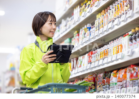 オンラインネットスーパー 商品をピックアップする女性スタッフ オンラインネットスーパー 商品をピックアップする女性スタッフ 140077374