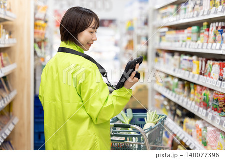 オンラインネットスーパー 商品をピックアップする女性スタッフ オンラインネットスーパー 商品をピックアップする女性スタッフ 140077396