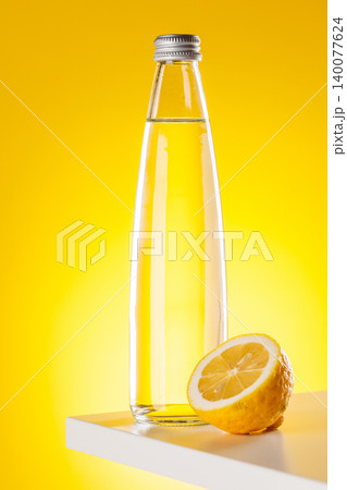 Sparkling water bottle with lemon yellow background refreshment 140077624