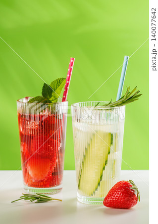 Fresh non alcoholic berry and cucumber drinks with herbs on green background Fresh non alcoholic berry and cucumber drinks with herbs on green background 140077642