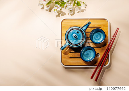 Blue teapot with blossom branch on wooden tray Blue teapot with blossom branch on wooden tray 140077662