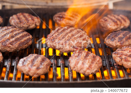 Burger patties grilling with fire and smoke Burger patties grilling with fire and smoke 140077672
