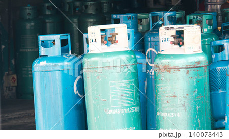 Collection of various weathered green and blue liquid petroleum gas (LPG) cylinders in storage Collection of various weathered green and blue liquid petroleum gas (LPG) cylinders in storage 140078443