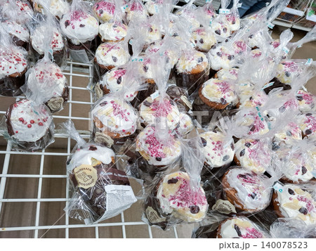 VORONEZH, Russia - April 25, 2026. Traditional Easter Kulich cakes are arranged on a high shelf at the grocery store. Each cake is topped with white icing and sprinkles, packed in clear plastic bags. VORONEZH, Russia - April 25, 2026. Traditional Easter Kulich cakes are arranged on a high shelf at the grocery store. Each cake is topped with white icing and sprinkles, packed in clear plastic bags. 140078523