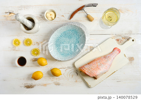 Preparation of red snapper with lemon and sauce on a kitchen table in the afternoon 140078529
