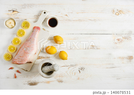 Preparing red snapper with lemon and spices on wooden table for cooking 140078531