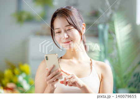 スマホを持つスポーツウェアの若い女性 スマホを持つスポーツウェアの若い女性 140079655