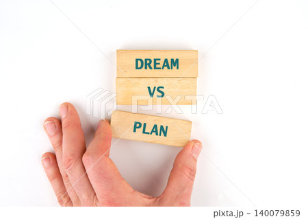 A human hand carefully places a wooden block with the word Plan written on it A human hand carefully places a wooden block with the word Plan written on it 140079859