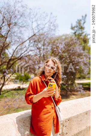 Young woman using smart phone and smile with walking in city outdoor. Business, blogging concept. 140079962
