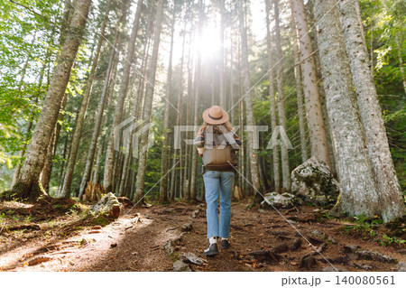 Woman with backpack hiking outdoors in the Forest. Trekking in the Pine Woods. Hiking lifestyle 140080561