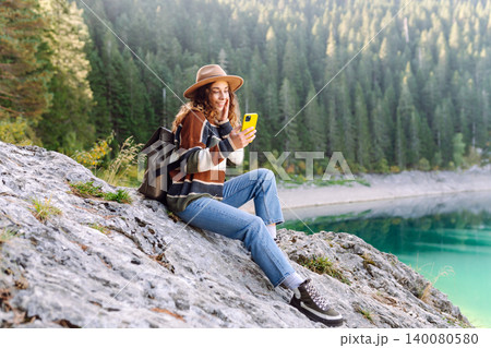 Young woman tourist uses a smartphone on the nature. Lifestyle, travel, tourism, active life. 140080580
