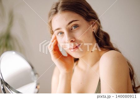 Young woman with problem skin looking into mirror. Inflammation on face, problem skin. Beauty care. Young woman with problem skin looking into mirror. Inflammation on face, problem skin. Beauty care. 140080911