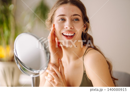 Young woman with problem skin looking into mirror. Inflammation on face, problem skin. Beauty care. Young woman with problem skin looking into mirror. Inflammation on face, problem skin. Beauty care. 140080915