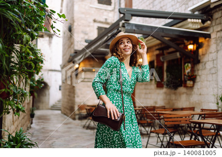 Young beautiful woman in trendy summer dress posing in street. Fashion style. Tourist attraction. 140081005