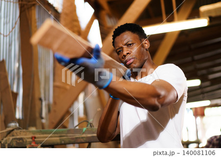 Factory worker inspecting wooden plank in workshop Factory worker inspecting wooden plank in workshop 140081106