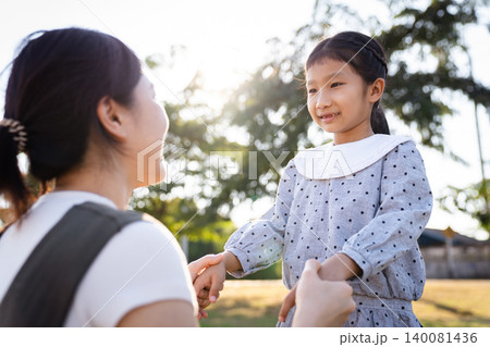 Happy Asian mother and daughter smiling together in the park Happy Asian mother and daughter smiling together in the park 140081436