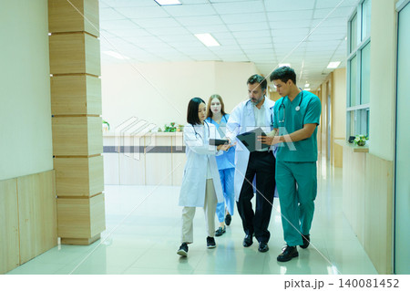 Group of diverse doctors walking and discussing in hospital corridor Group of diverse doctors walking and discussing in hospital corridor 140081452