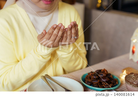 Muslim Woman Praying Before Iftar Meal During Ramadan at Home Muslim Woman Praying Before Iftar Meal During Ramadan at Home 140081614