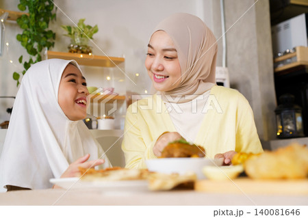 Muslim Mother and Daughter Enjoying Ramadan Iftar Meal at Home Muslim Mother and Daughter Enjoying Ramadan Iftar Meal at Home 140081646