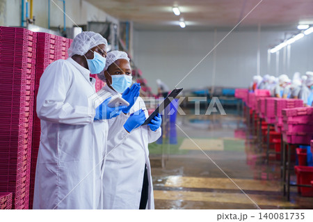 Food Safety Inspectors Monitoring Production in Seafood Processing Plant Food Safety Inspectors Monitoring Production in Seafood Processing Plant 140081735