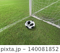 Deflated soccer ball on green grass field near the goal post, failure or missed opportunity concept 140081852