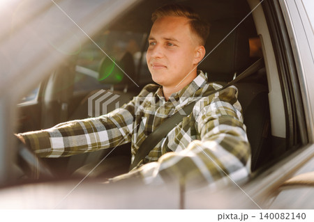 Portrait of handsome young man sitting in the driving seat of his car. Car travel, lifestyle concept Portrait of handsome young man sitting in the driving seat of his car. Car travel, lifestyle concept 140082140