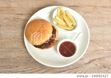 fried mashed beef meat hamburger dressing barbecue sauce with crispy French fries dipping ketchup on plate fried mashed beef meat hamburger dressing barbecue sauce with crispy French fries dipping ketchup on plate 140082427