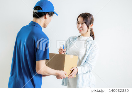 荷物の伝票にサインをする女性 140082880