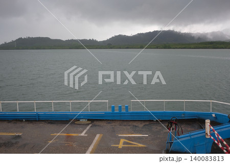 View from a Ferry Deck Crossing the Sea Towards a Misty Tropical Island Under an Overcast Sky in Krabi View from a Ferry Deck Crossing the Sea Towards a Misty Tropical Island Under an Overcast Sky in Krabi 140083813