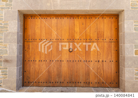 Traditional wooden gate set within stone masonry facade in Rupit village, Catalonia, Spain Traditional wooden gate set within stone masonry facade in Rupit village, Catalonia, Spain 140084841