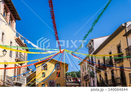Colorful festival streamers above historic street in Sant Feliu de Pallerols Catalonia Colorful festival streamers above historic street in Sant Feliu de Pallerols Catalonia 140084844