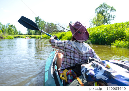 Woman paddling kayak on peaceful river, enjoying outdoor tourism, summer travel, water sport adventure and recreation gear. Woman paddling kayak on peaceful river, enjoying outdoor tourism, summer travel, water sport adventure and recreation gear. 140085440