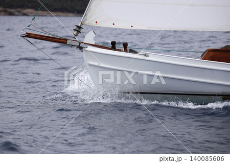 Close up on the bow of a sailboat breaking through a wave Close up on the bow of a sailboat breaking through a wave 140085606