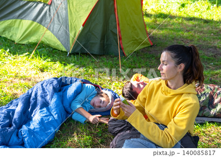 Mother applies mosquito repellent to daughter in tent, outdoor protection for children, healthy active family vacation. Mother applies mosquito repellent to daughter in tent, outdoor protection for children, healthy active family vacation. 140085817