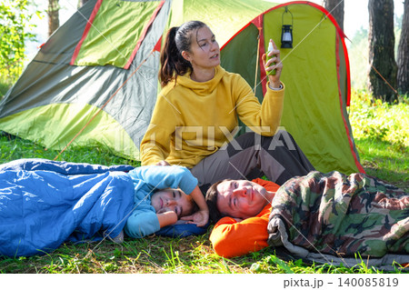 Mother at tent with spray bottle, providing insect bite protection for family, safe holidays, outdoors and recreation. Mother at tent with spray bottle, providing insect bite protection for family, safe holidays, outdoors and recreation. 140085819