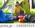 Mother with children in tent, spraying mosquito repellent, healthy camping vacation, bite prevention, safety for family group. 140085919