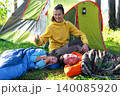 Mother applies repellent, children at tent, bug bite protection, safe leisure, healthy camping, prevention for group outdoors. 140085920