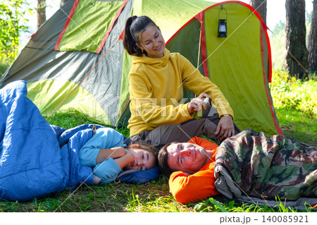 Mother in tent applies bug repellent to children, family health, protection from insect bites, wellness, camping safety, outdoor fun. Mother in tent applies bug repellent to children, family health, protection from insect bites, wellness, camping safety, outdoor fun. 140085921