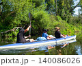 Family paddling the Varzuga kayak on a river, group water travel, teamwork and fun nature adventure for all ages. 140086026