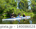 Family in the Varzuga kayak paddling the river, active summer water adventure, teamwork, healthy recreation, leisure for parents and kids. 140086028