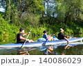 Parents and child paddling the Vuoksa kayak on a calm river, family water trip, teamwork, active summer recreation and healthy leisure. 140086029